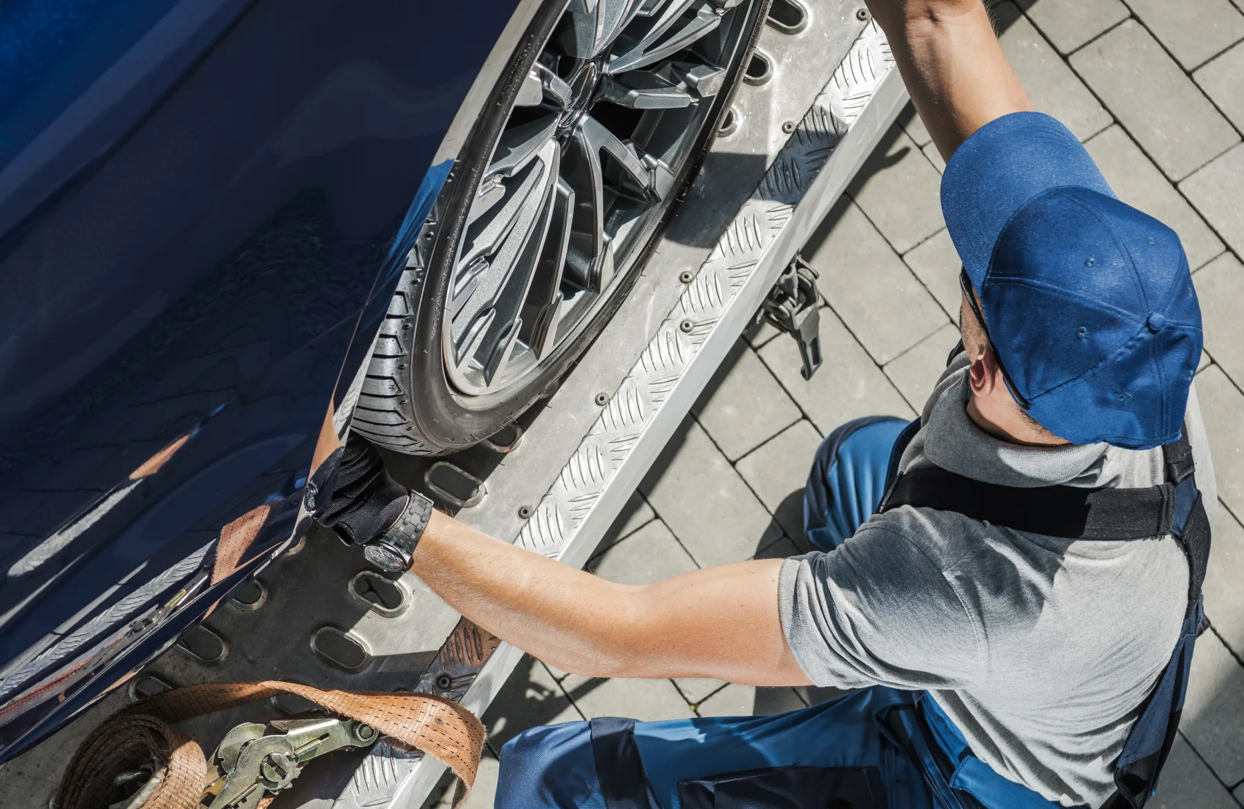 Tekniker säkrar en bil på transportflak inför biltransport